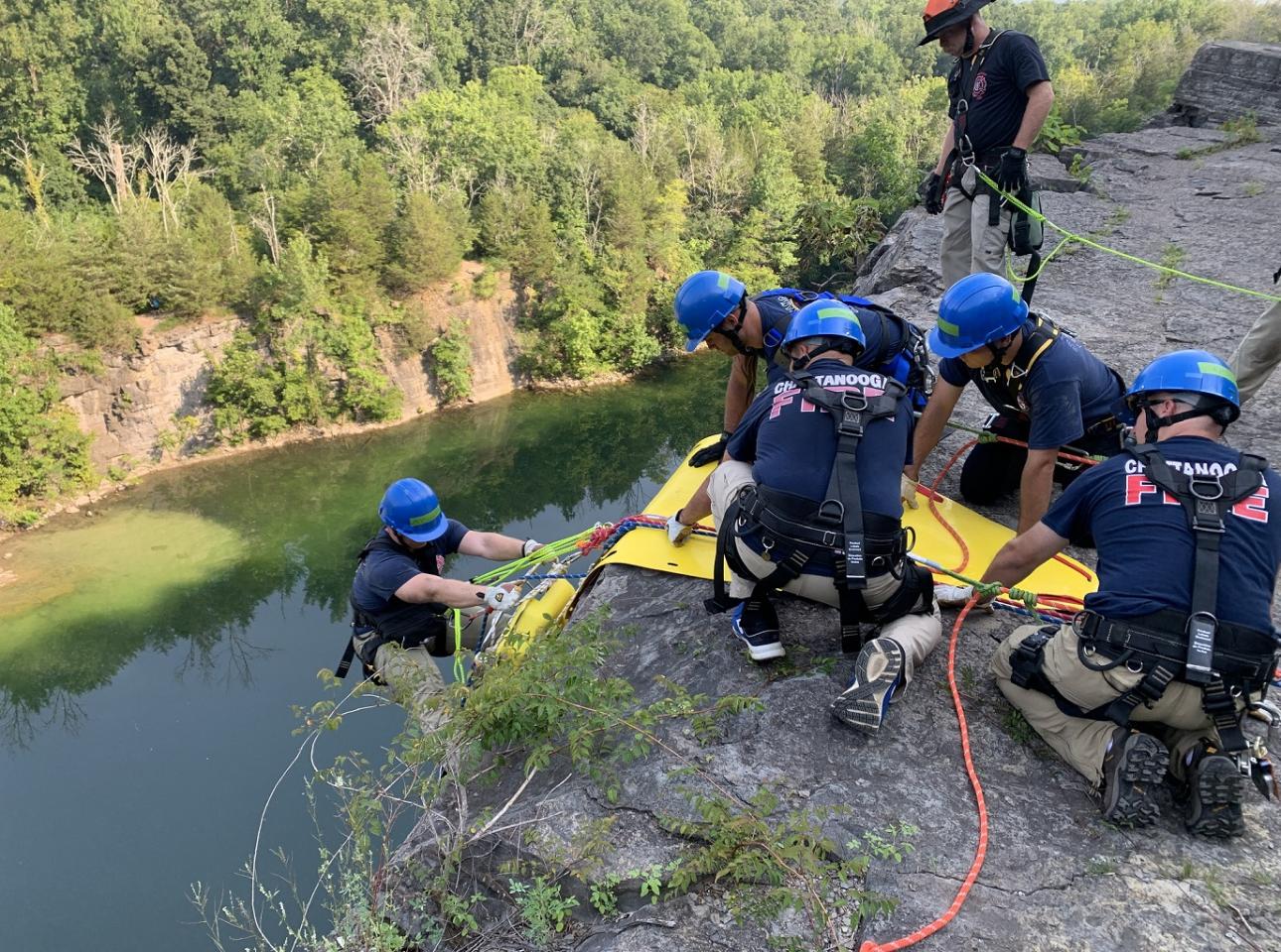 A group of people on a cliff, using a special ops rope for their mission.