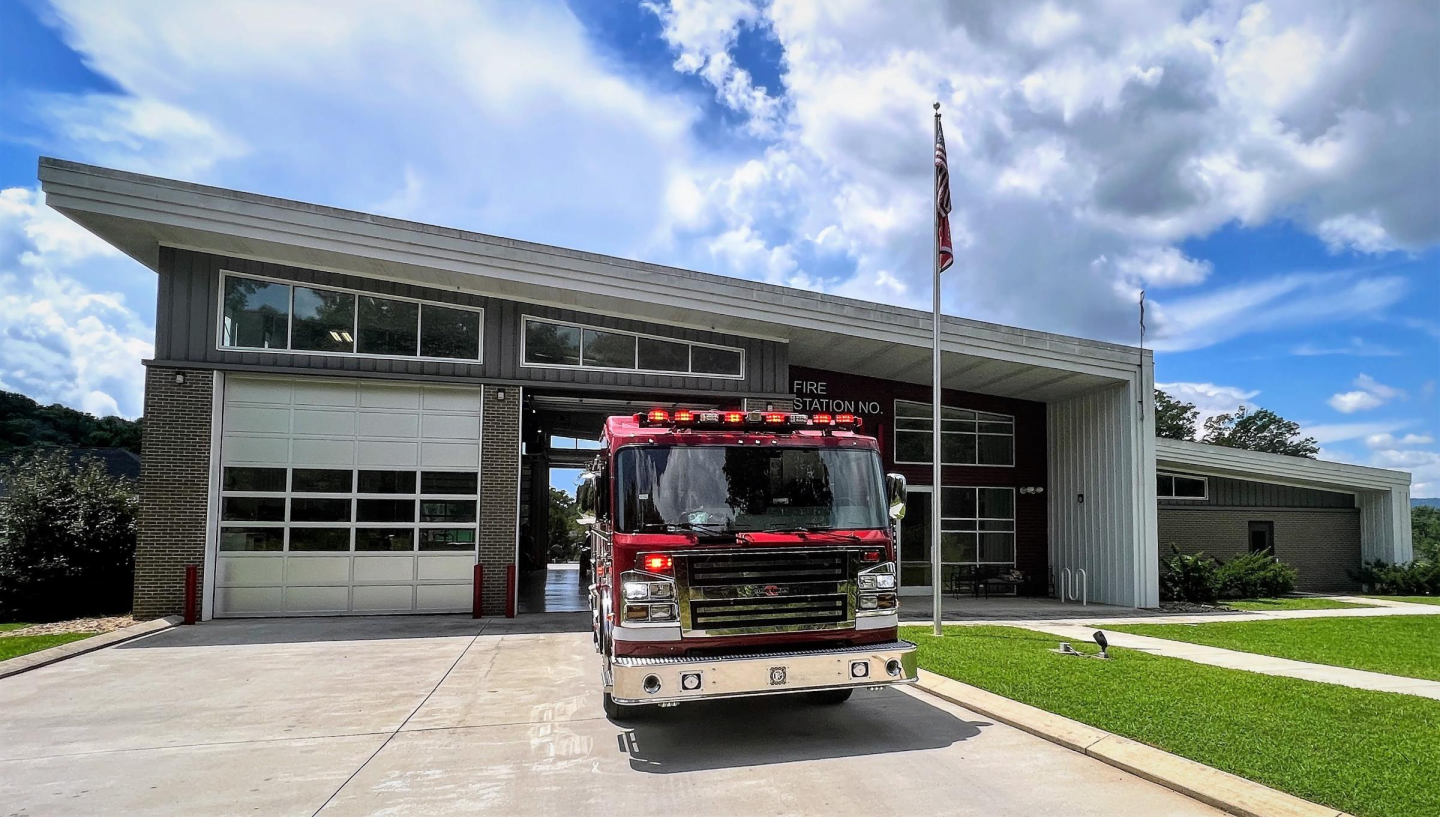 A fire truck parked in front of a large building at fire station 11.