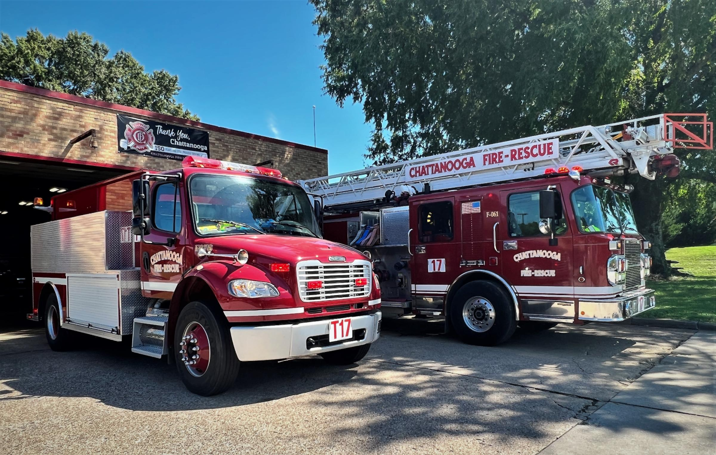 Two red fire trucks parked in front of a building at fire station 17.