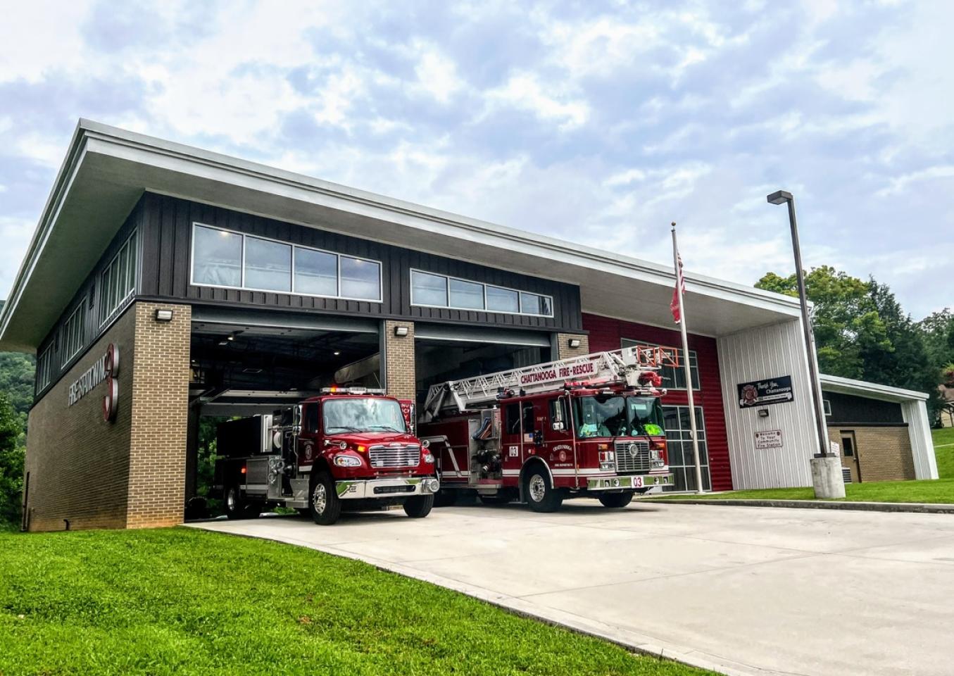 Two fire trucks parked in front of a building at fire station 3.