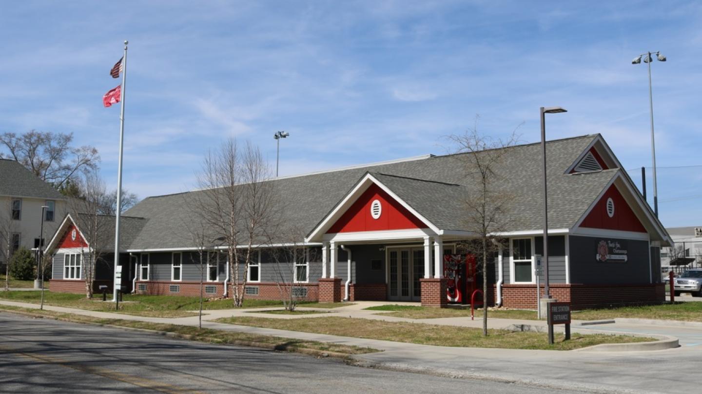 Red and gray fire station 5 building with flag pole.