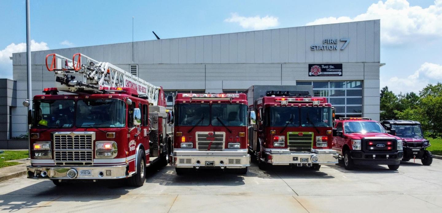 Front view of Chattanooga Fire Station 7 showing various fire trucks and an all-terrain vehicle parked outside the station.