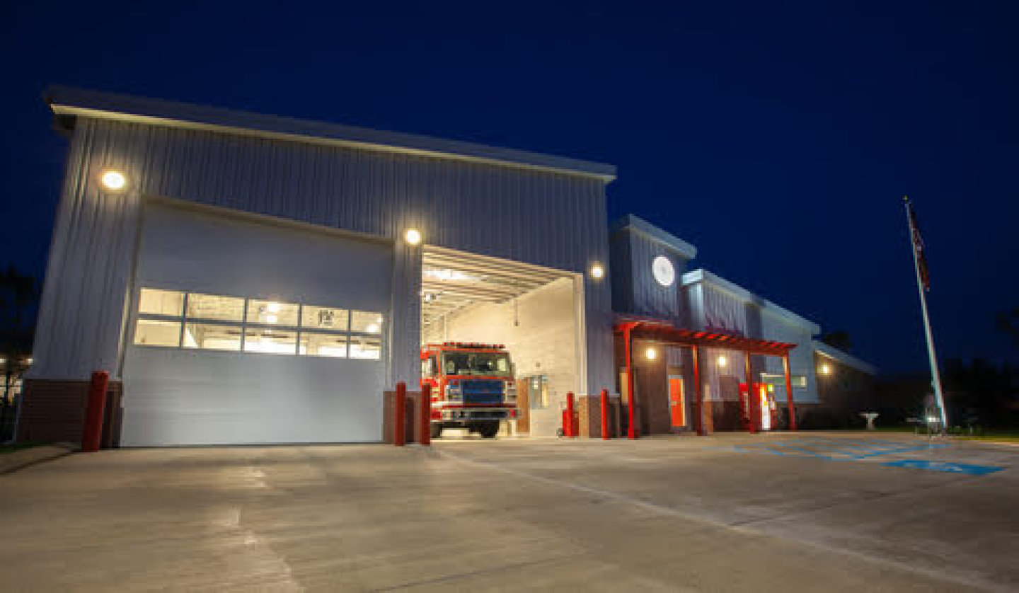 Fire Station 9 with open garage door at night.