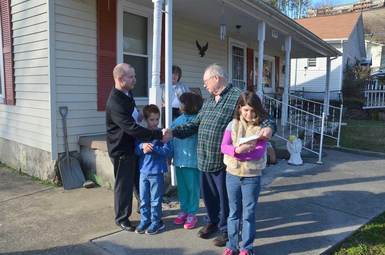 Firefighters Present Check to Survivors of Tragic Fire